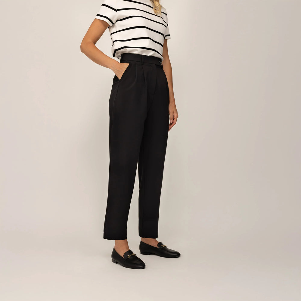 Woman wearing Marame High-Waisted Tapered Trousers in Black, front view.