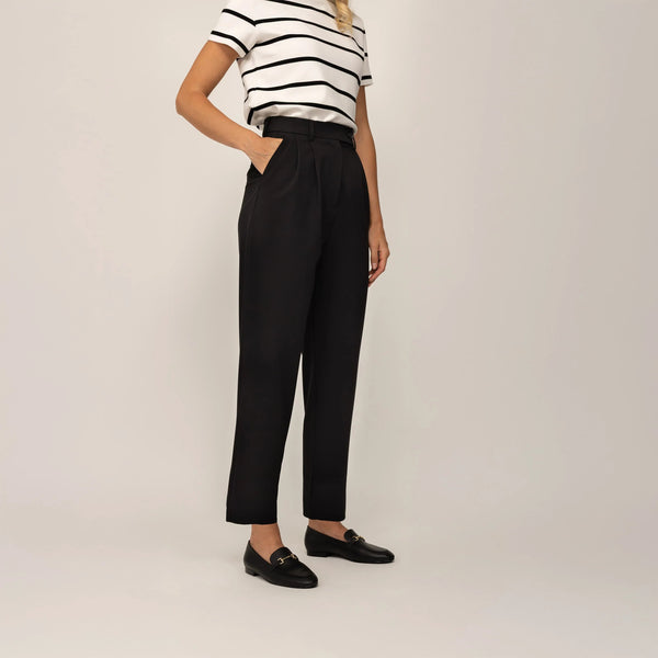 Woman wearing Marame High-Waisted Tapered Trousers in Black, front view. |black