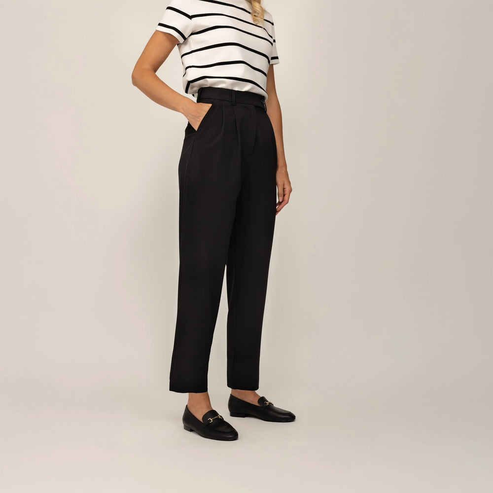 Woman wearing Marame High-Waisted Tapered Trousers in Black, front view. |black