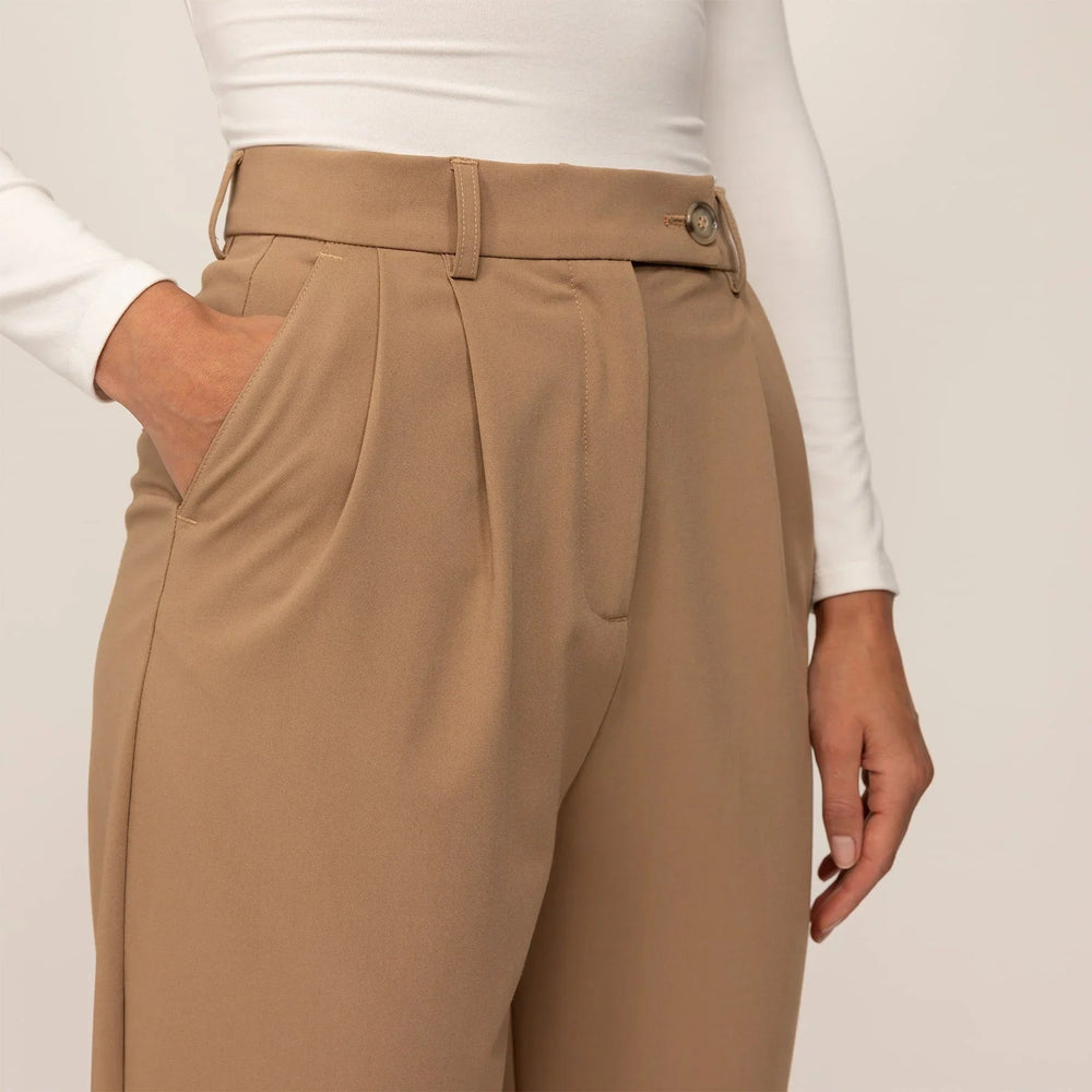 Woman wearing High-Waisted Tapered Trousers in Caramel, closeup. |caramel