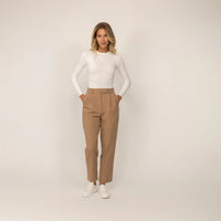 Woman wearing Marame High-Waisted Tapered Trousers in Caramel, full. |caramel