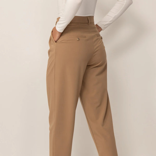Woman wearing High-Waisted Tapered Trousers in Caramel, rear view. |caramel