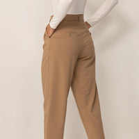 Woman wearing High-Waisted Tapered Trousers in Caramel, rear view. |caramel