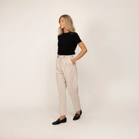 Woman wearing Marame High-Waisted Tapered Trousers in Stone, full view. |stone