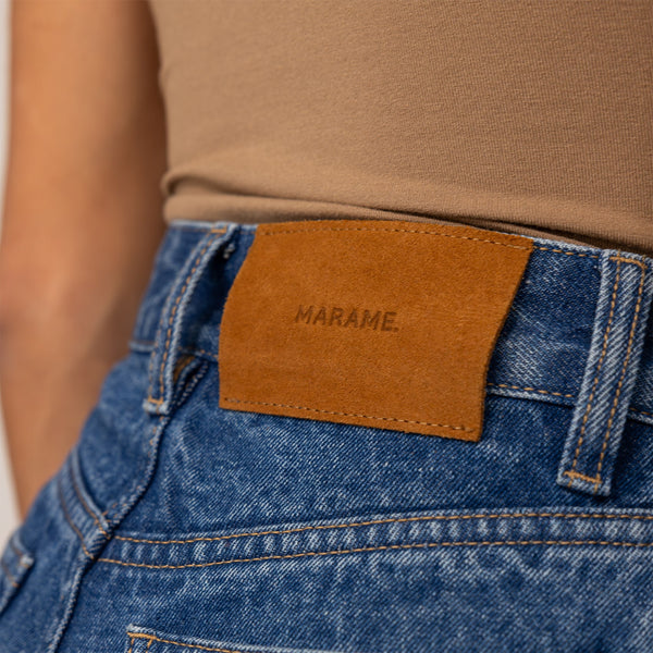 Woman wearing High-Waisted Wide Leg Jeans in Deep Wash Navy Denim, closeup.