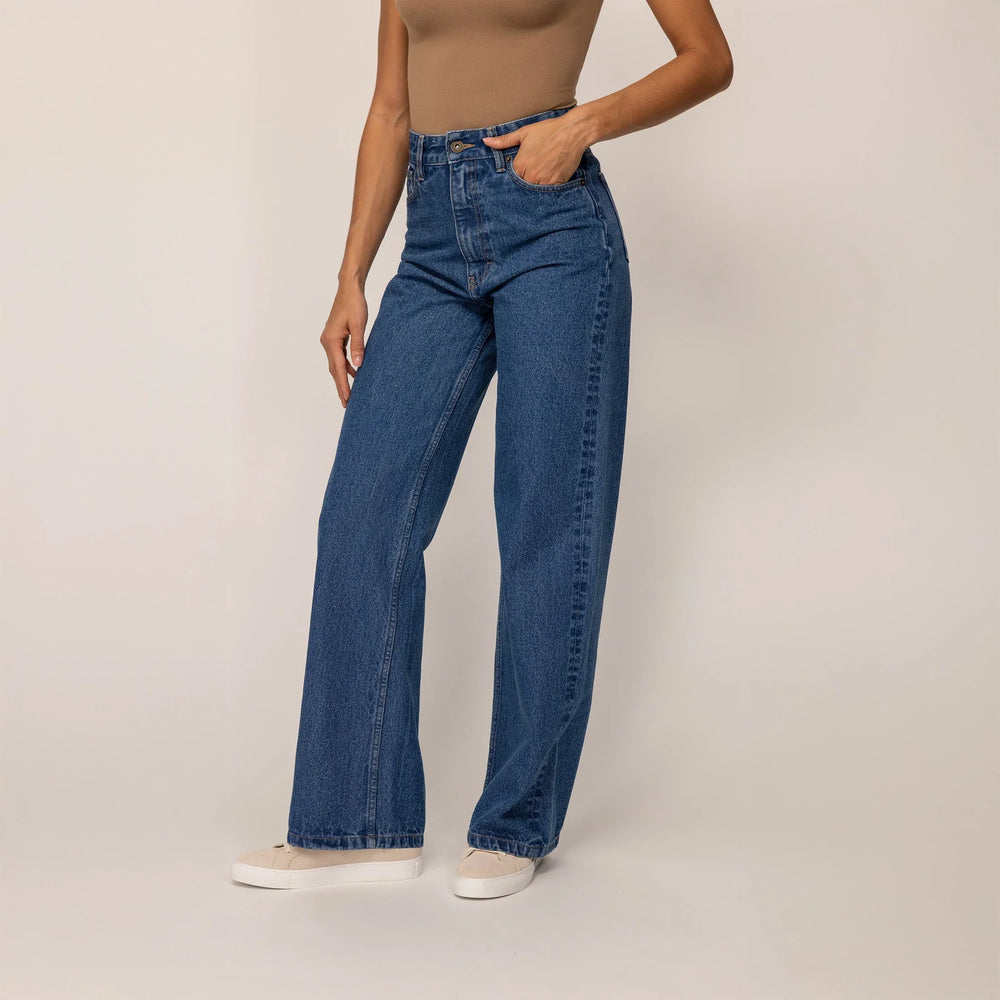 Woman wearing Marame High-Waisted Wide Leg Jeans in Deep Wash Navy Denim, front view.