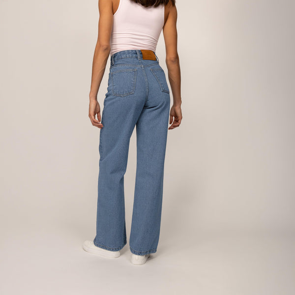 Woman wearing High-Waisted Wide Leg Jeans in Light Wash Denim, rear view. |blue wash denim