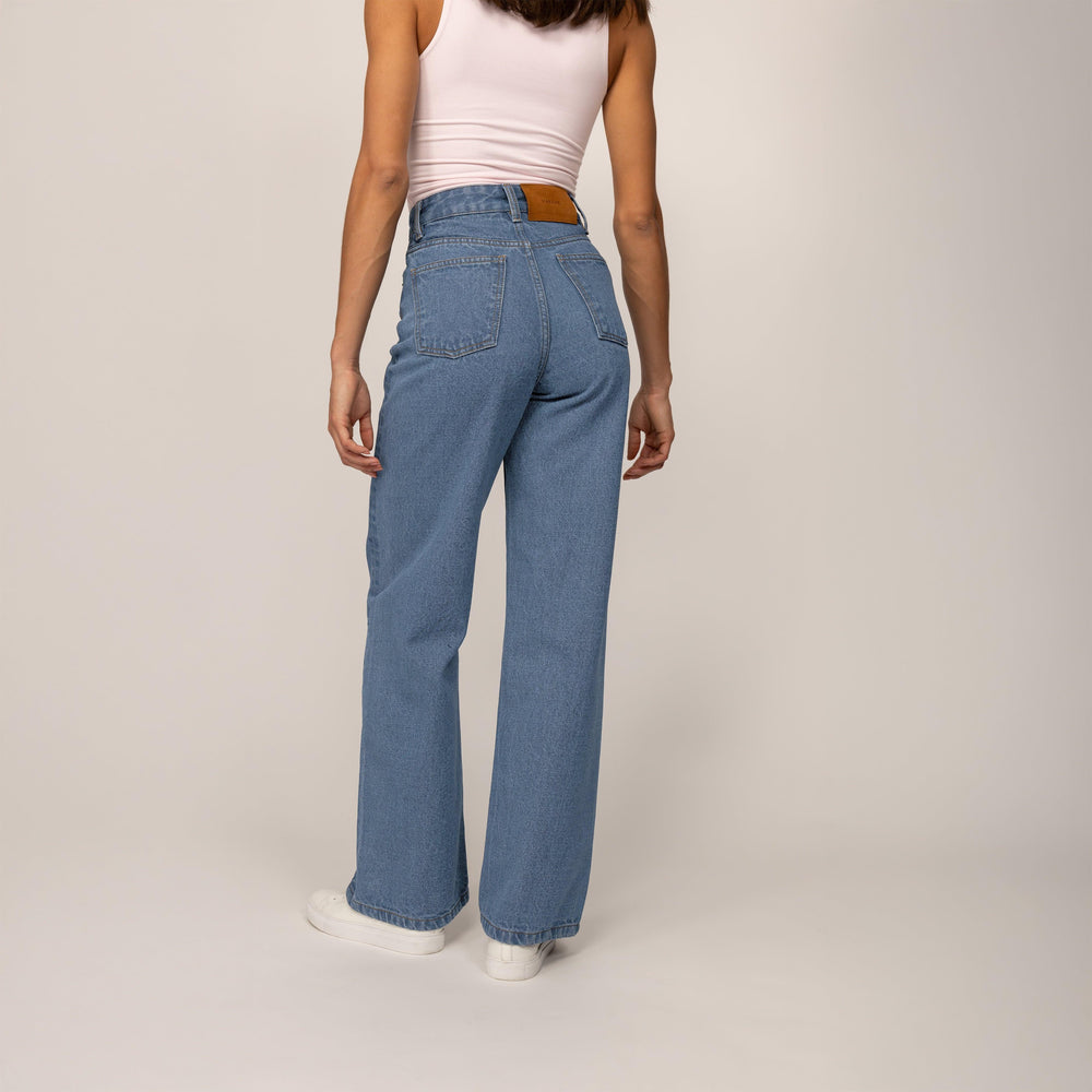 Woman wearing High-Waisted Wide Leg Jeans in Light Wash Denim, rear view. |blue wash denim