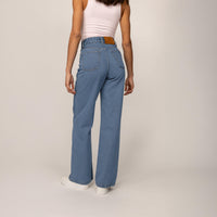 Woman wearing High-Waisted Wide Leg Jeans in Light Wash Denim, rear view. |blue wash denim