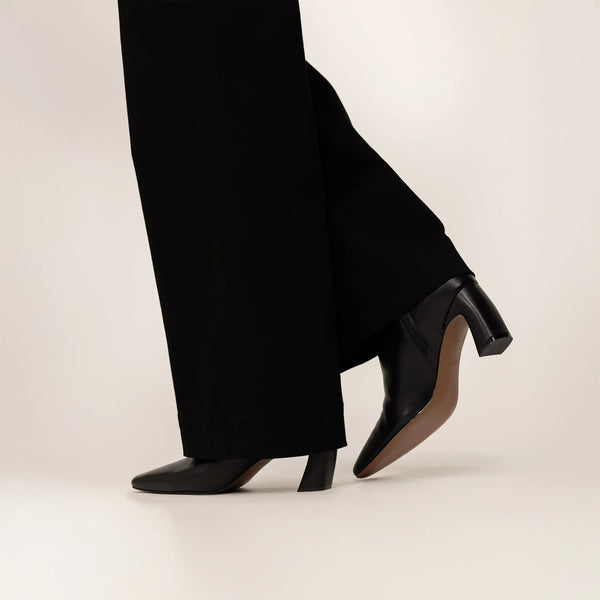 woman wearing Marame Leather Ankle Boots in Black, side view. |black
