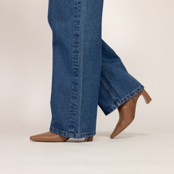 Woman wearing Marame Leather Ankle Boots in Brown, side view.