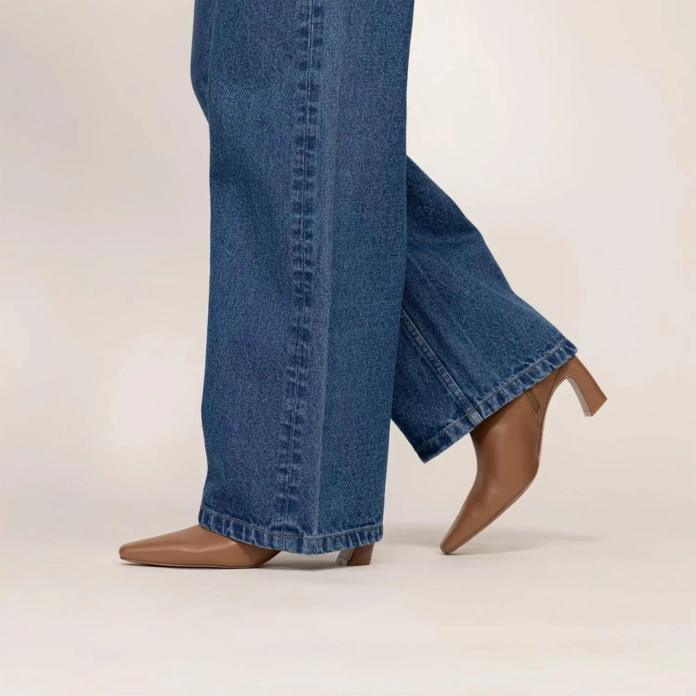 Woman wearing Marame Leather Ankle Boots in Brown, side view. |brown