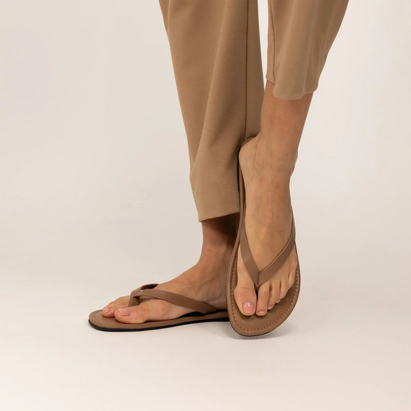 Woman wearing Marame Leather Flip Flops in Brown, front view. |brown