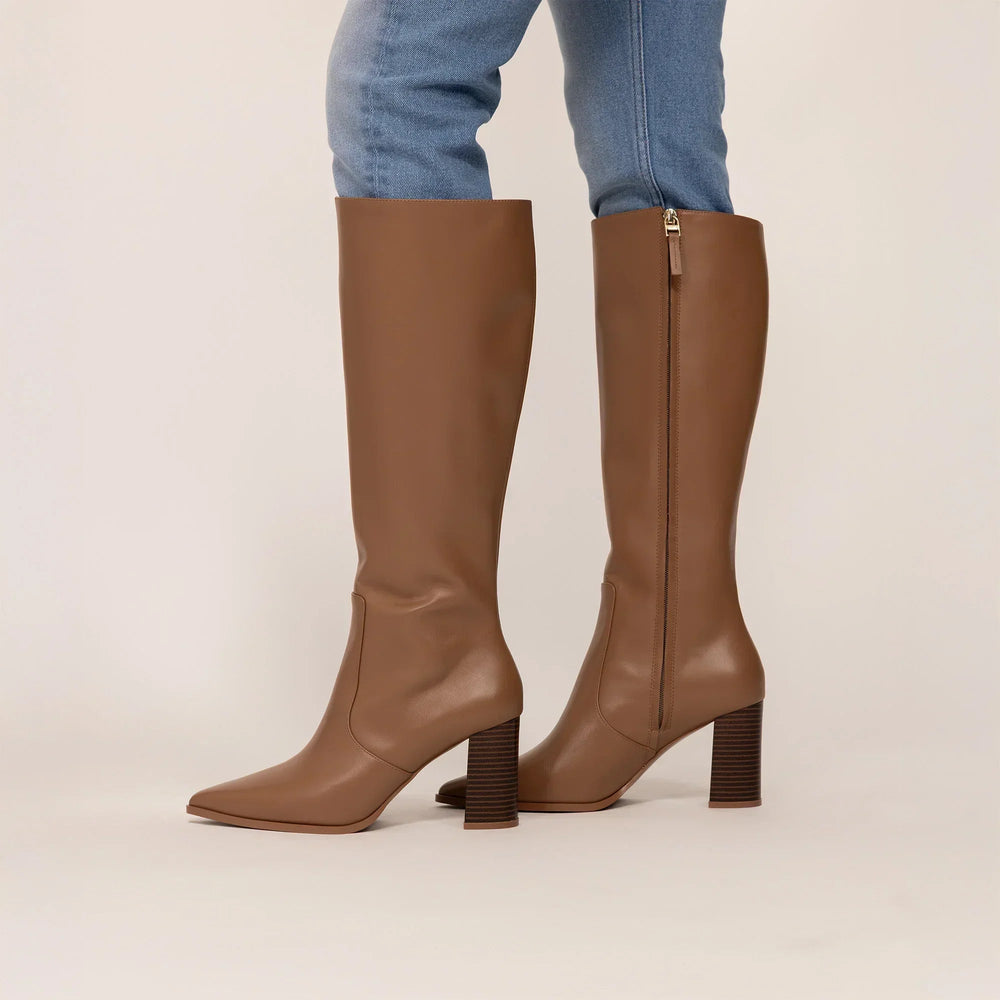 Woman wearing Marame Leather Knee-High Boots in Brown, side view. |brown