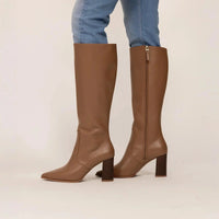 Woman wearing Marame Leather Knee-High Boots in Brown, side view. |brown