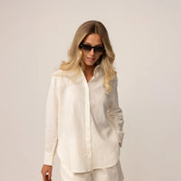 Woman posing in off white linen blend shirt and shorts