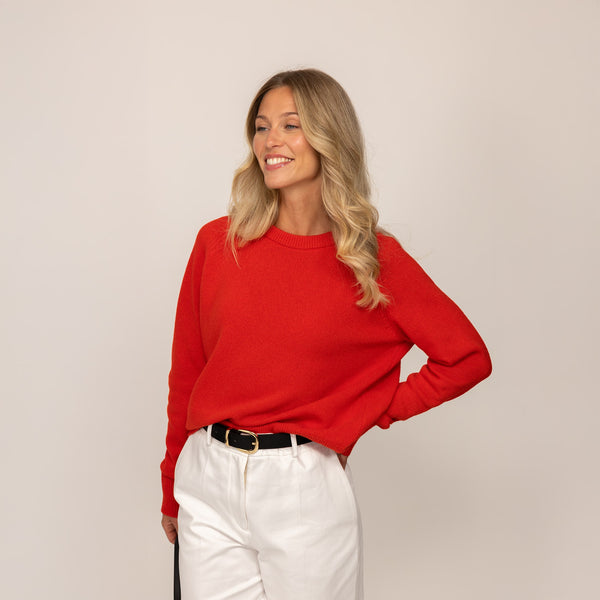 Woman wearing a Marame Merino Wool Crew Neck Jumper in Fiery Rose, front view.