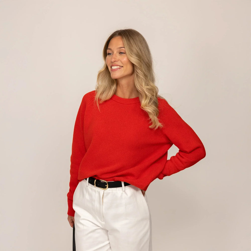Woman wearing a Marame Merino Wool Crew Neck Jumper in Fiery Rose, front view.
