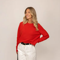 Woman wearing a Marame Merino Wool Crew Neck Jumper in Fiery Rose, front view.