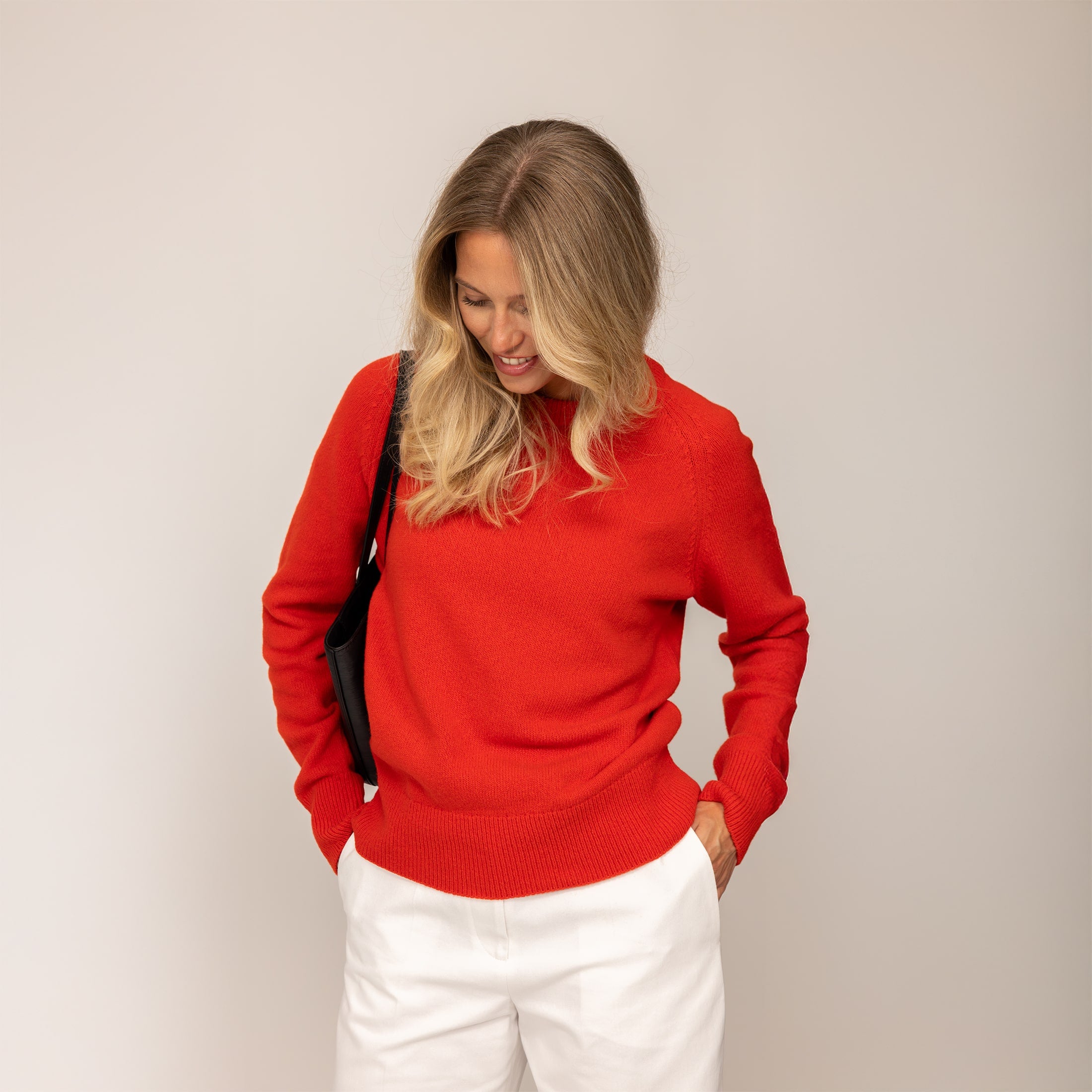 Woman wearing a Merino Wool Crew Neck Jumper in Fiery Rose, front view.