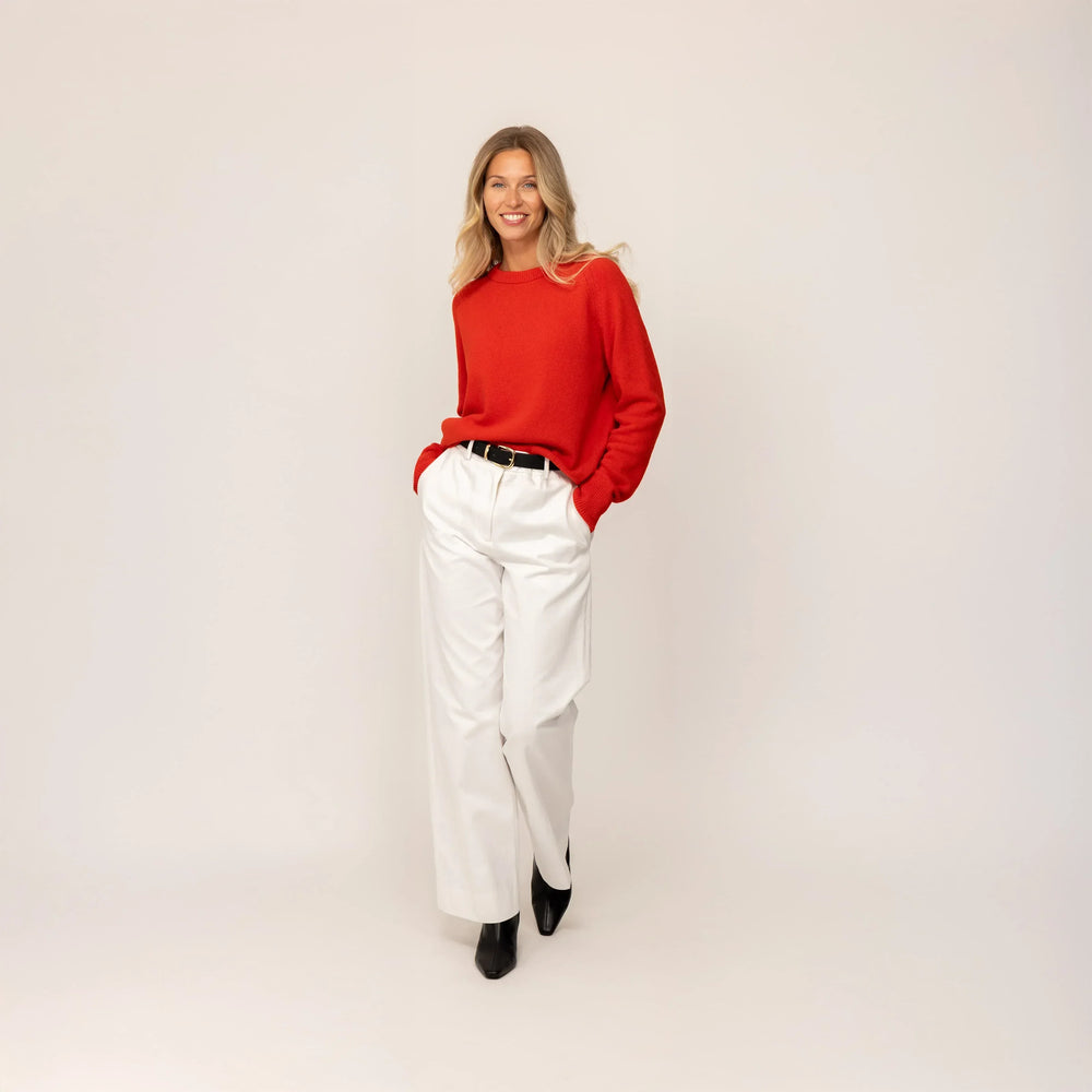 Woman wearing a Marame Merino Wool Crew Neck Jumper in Fiery Rose, full view.
