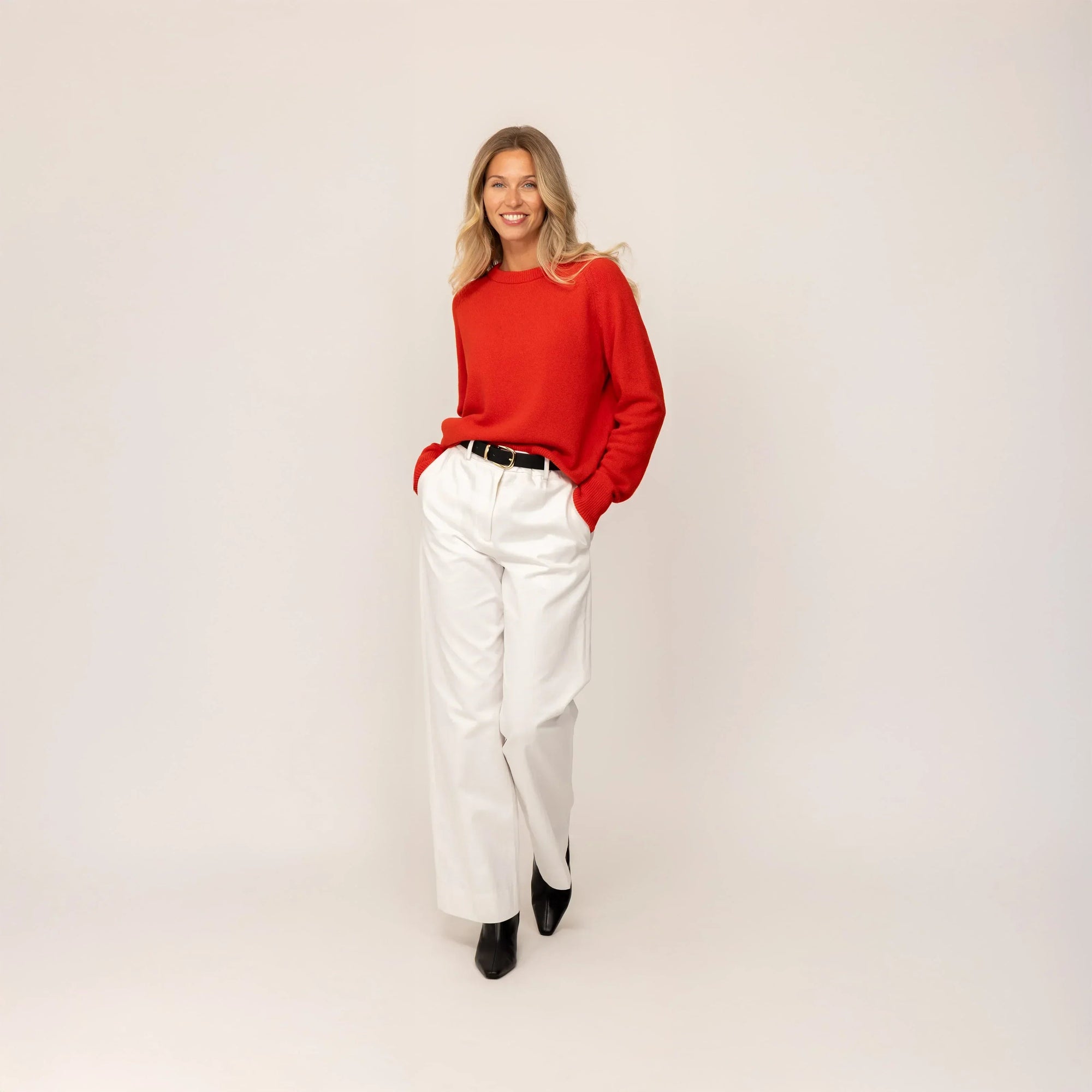 Woman wearing a Marame Merino Wool Crew Neck Jumper in Fiery Rose, full view.|fiery rose