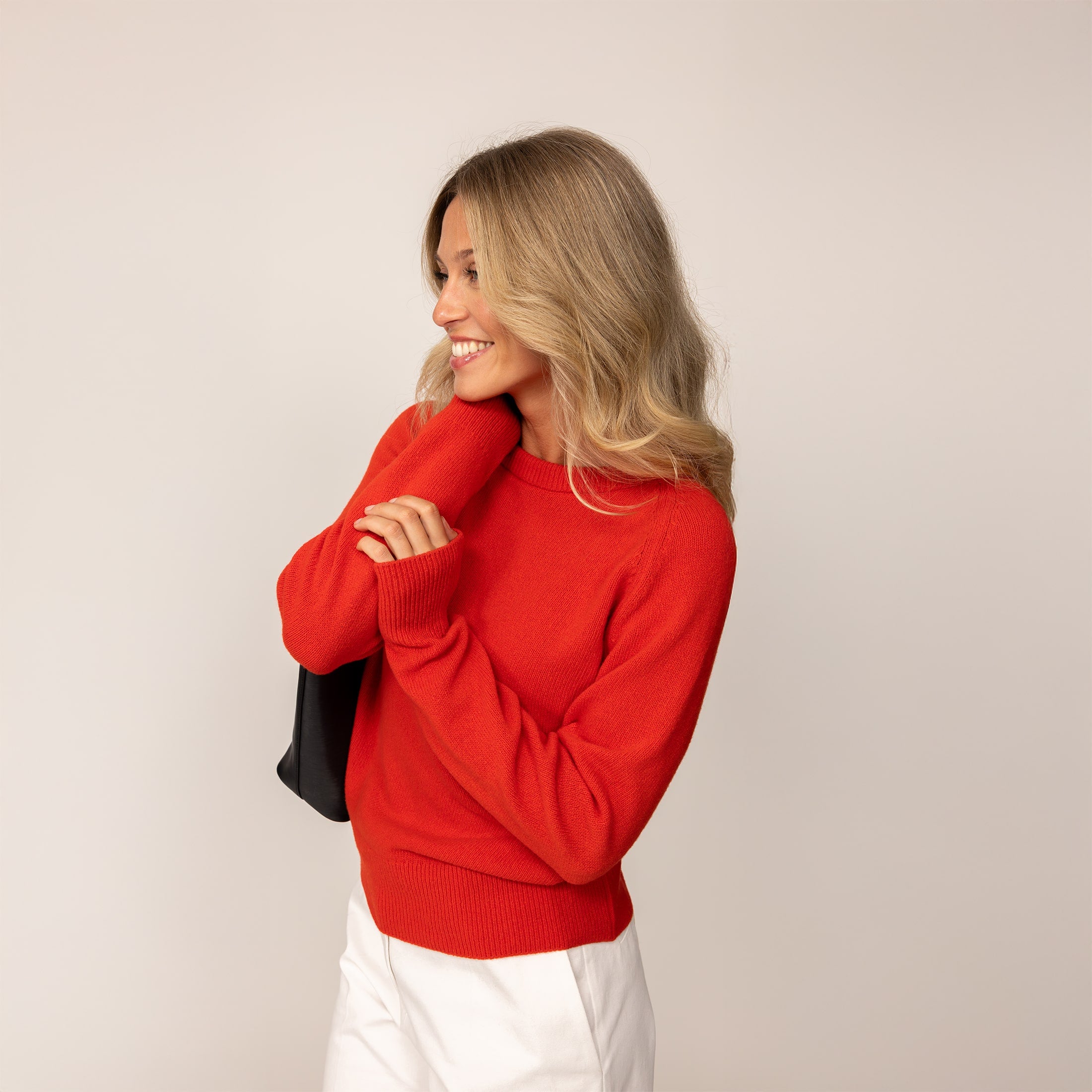 Woman wearing a Marame Merino Wool Crew Neck Jumper in Fiery Rose, front view.