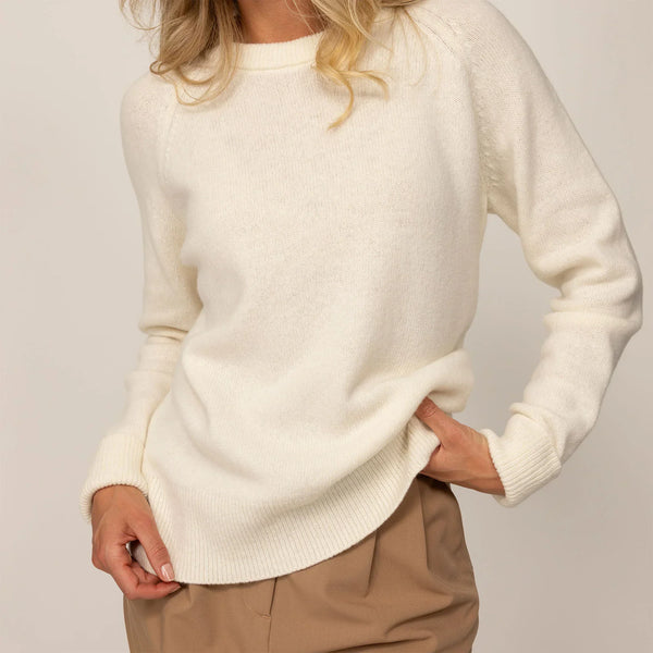 Woman wearing a Merino Wool Crew Neck Jumper in Vanilla Cream, detail.