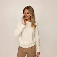 Woman wearing a Marame Merino Wool Crew Neck Jumper in Vanilla Cream, front view.
