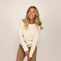 Woman wearing a Marame Merino Wool Crew Neck Jumper in Vanilla Cream, front view.