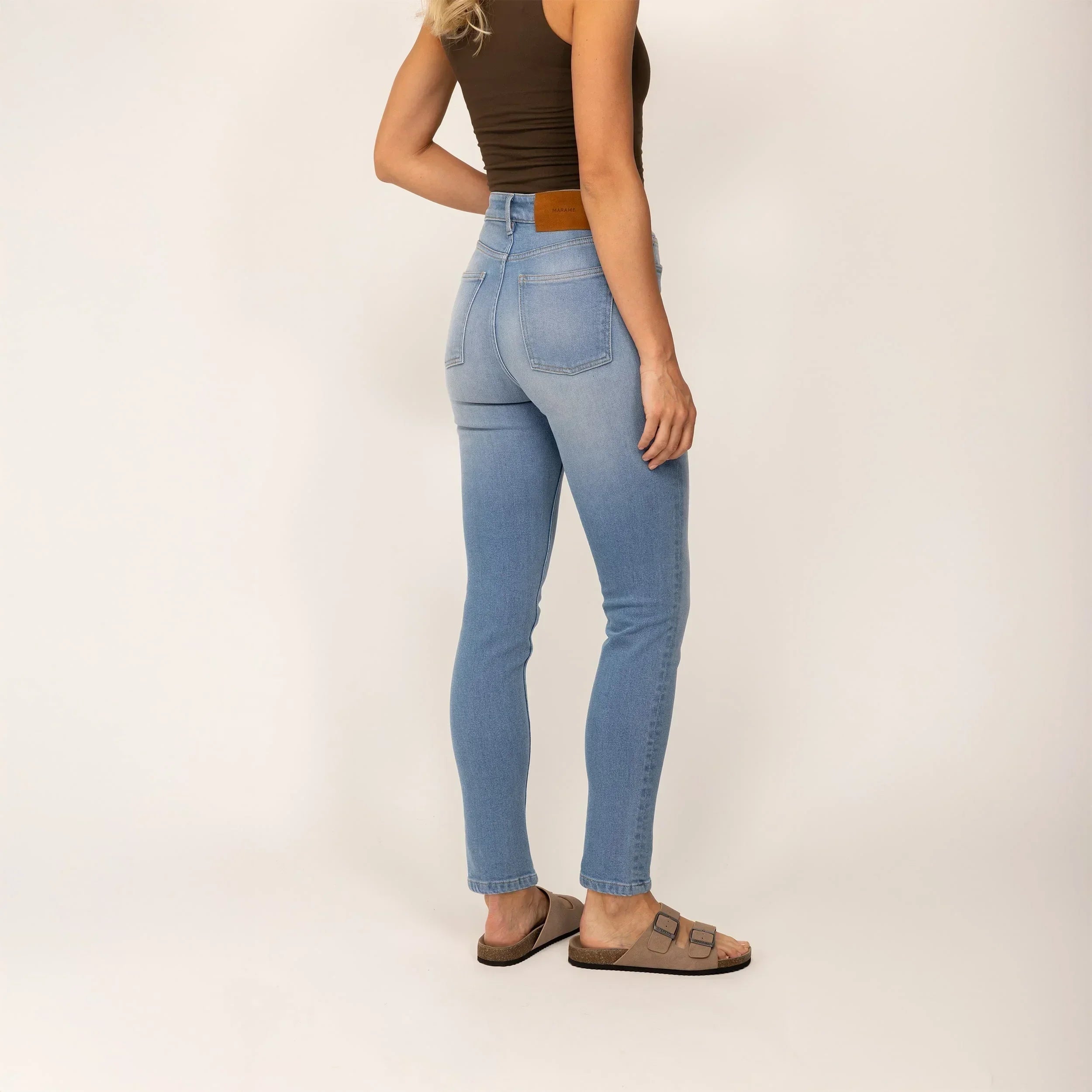 Woman wearing Slim Leg Jeans in Light Wash Denim, rear view. |light wash denim