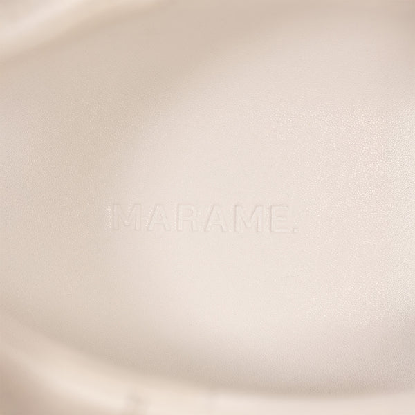 Woman wearing Marame Smart Leather Trainers in White, closeup.