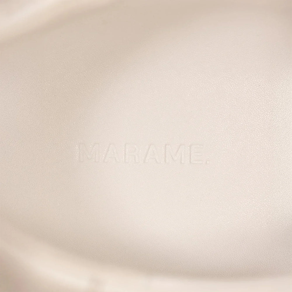 Woman wearing Marame Smart Leather Trainers in White, closeup.