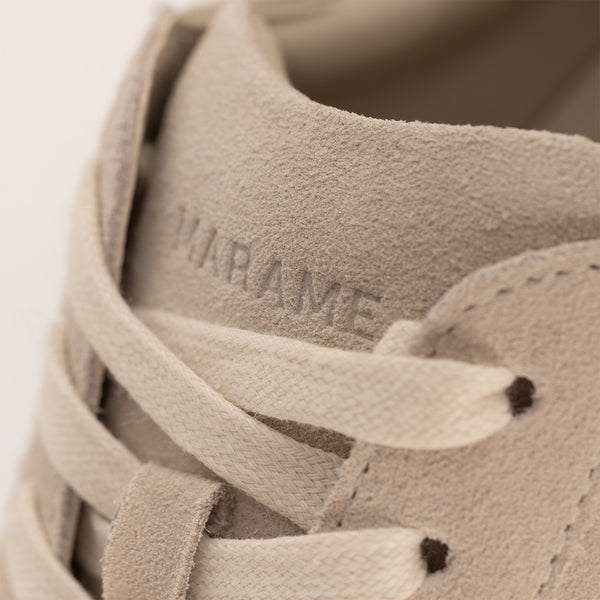 Woman wearing Marame Smart Suede Trainers in Grey, closeup.