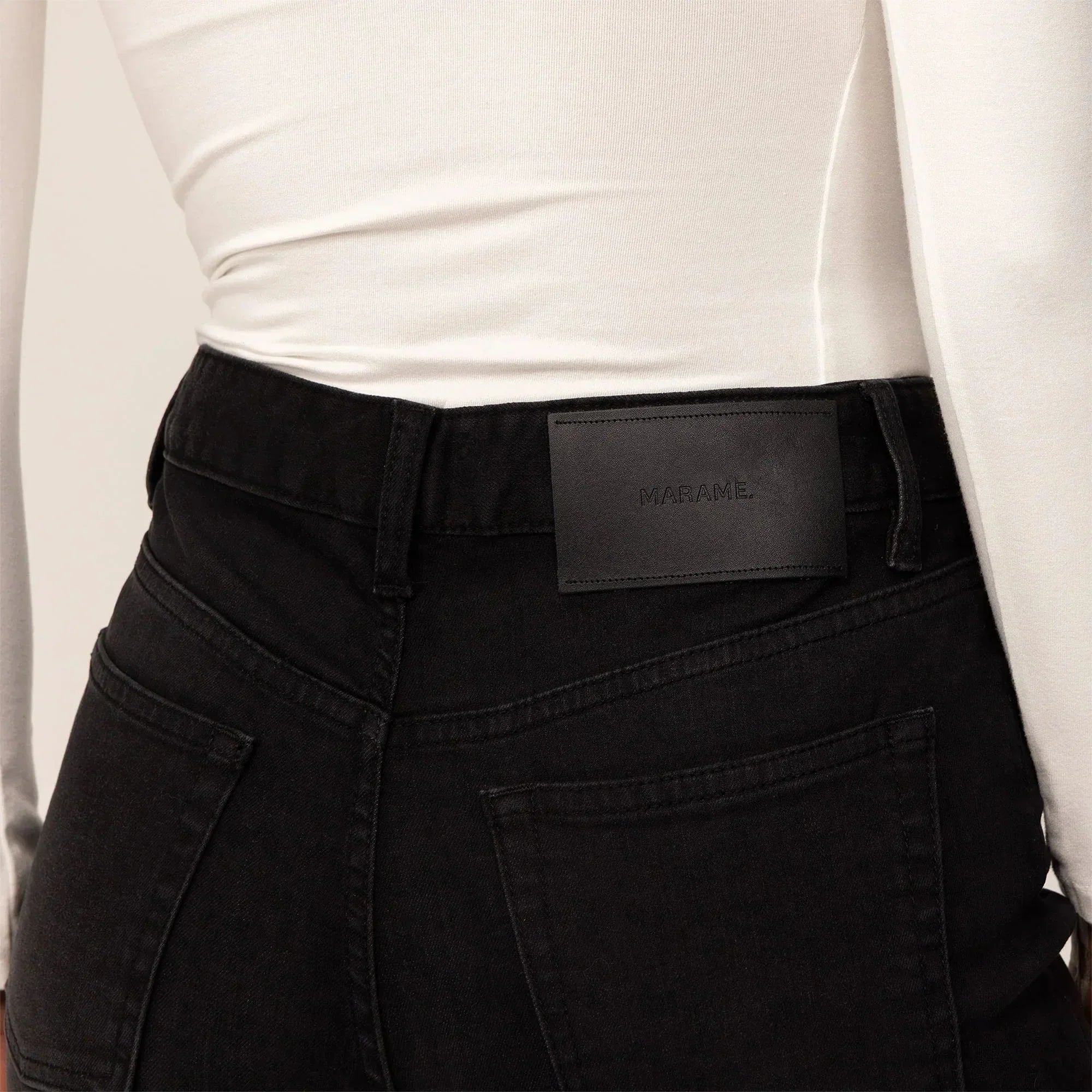 Woman wearing Marame Straight Leg Jeans in Black Wash Denim, closeup. |black wash denim