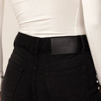 Woman wearing Marame Straight Leg Jeans in Black Wash Denim, closeup. |black wash denim